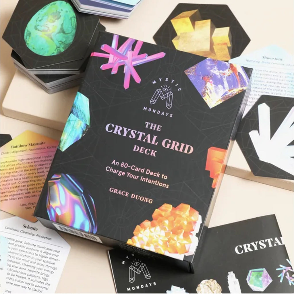 The Crystal Grid Deck box by Grace Doong from The Mindful Muse, displayed on a light beige surface surrounded by its cards and crystal-themed accessories.
