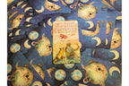 A tarot card deck spread out on a matching patterned surface, with the central card showing 'The Little Prince' artwork and the surrounding cards featuring a blue space design with crescent moons and planets.