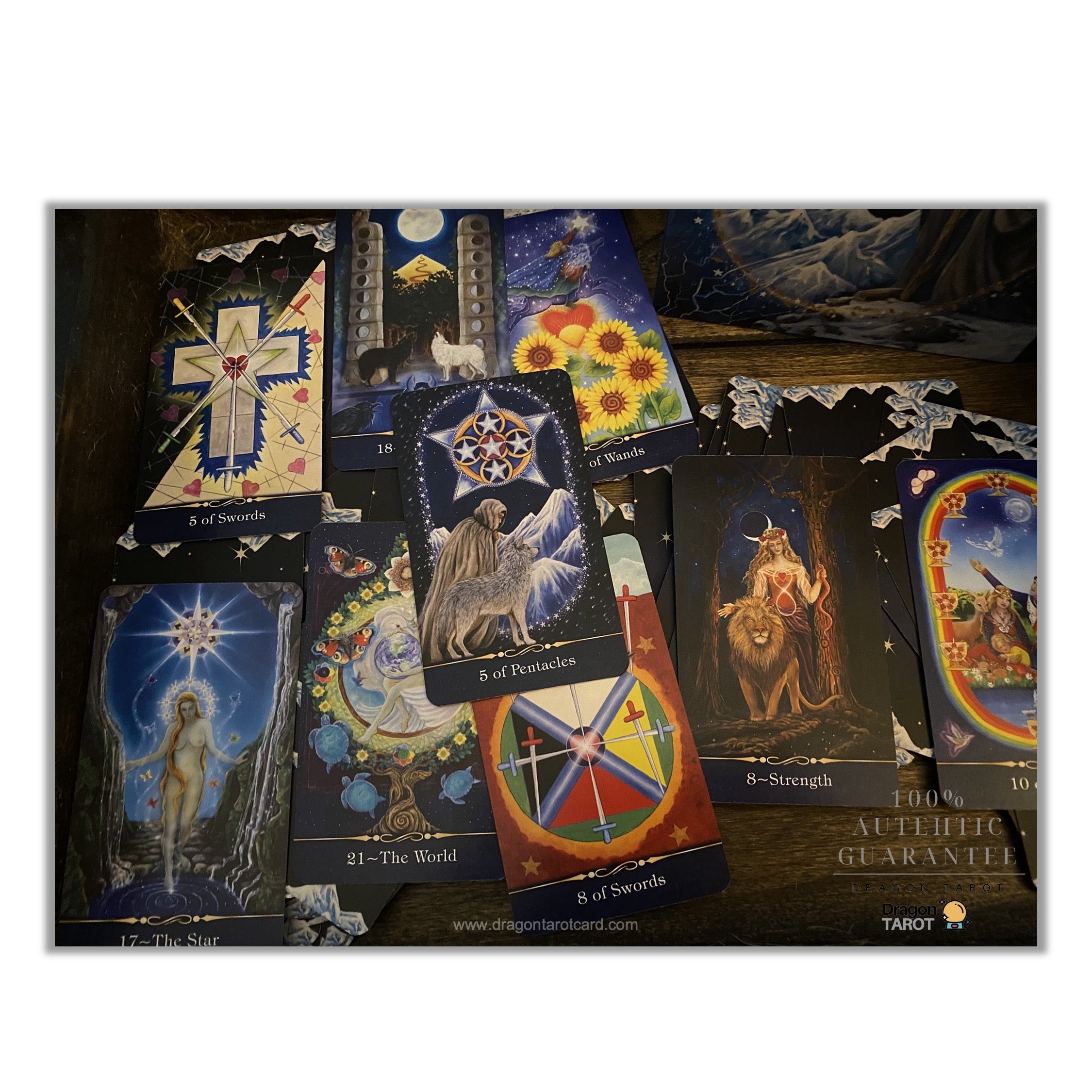 A set of illustrated tarot cards spread out on a dark surface, featuring mystical and celestial artwork in blue, gold, red, and black tones.