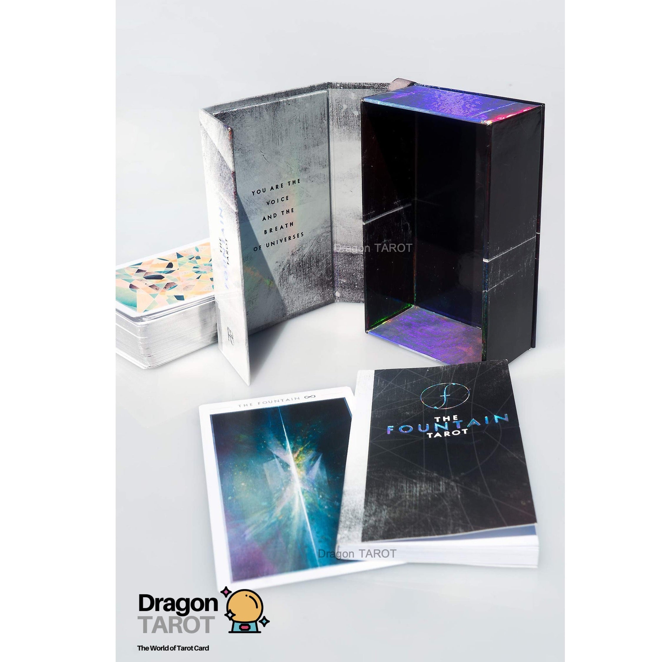 The Fool Tarot deck shown with its black outer box, open inner packaging, card deck box, and two cards on a light gray background. A Dragon Tarot logo watermark is visible in the lower-left corner.