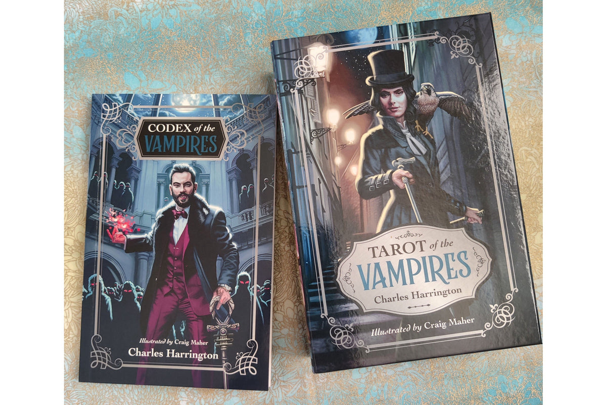 Two illustrated booklets or boxes for a vampire-themed product, titled 'Codex of the Vampires' and 'Tarot of the Vampires', shown on a textured light blue and gold background. The covers feature gothic artwork of a man in a top hat and coat, with decorative borders and fantasy-style illustration details.