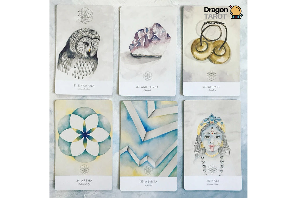Six illustrated tarot cards arranged in a 2x3 grid on a light marble-like surface. The cards feature watercolor-style drawings of an owl, crystals, earrings, a flower, geometric lines, and a stylized face.