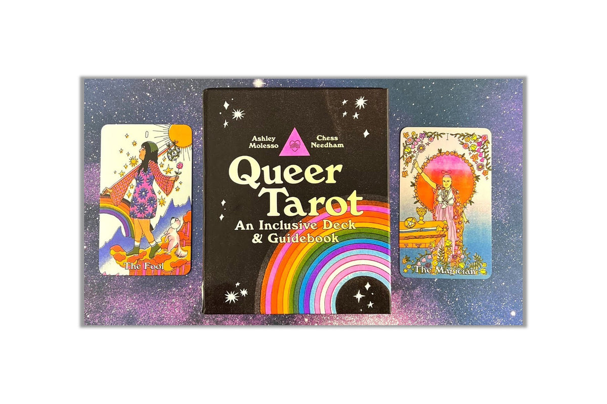 Queer Tarot deck and guidebook set featuring a central black box with a rainbow and the title 'Queer Tarot' flanked by two illustrated tarot cards on a purple glittery background.