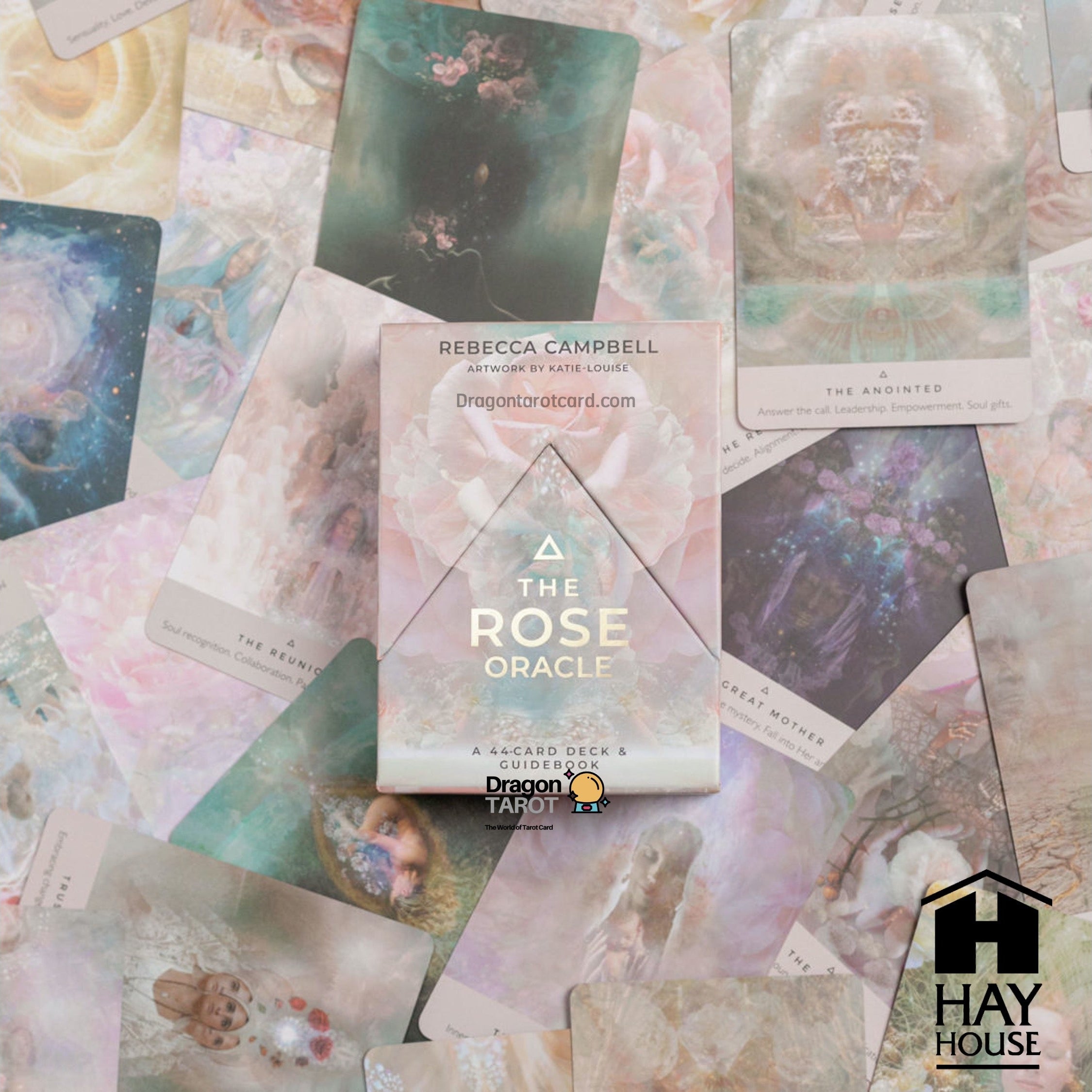 The Rose Oracle card deck box by Rebecca Campbell, displayed on top of a scattered arrangement of its illustrated oracle cards. The box features a light pink and white design with a central rose graphic.