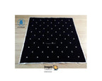 A black square tarot card deck cover featuring a celestial pattern of embroidered white crescent moons and stars, laid flat on a light wood floor. The brand logo 'Dragon Tarot' is visible at the bottom of the image.
