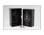 Two black textured product boxes standing upright on a light gray background. The left box features a white hand outline, and the right box has a circular crest with the text '17 PRUTIE NOT COSSS CLOESS TROY'.