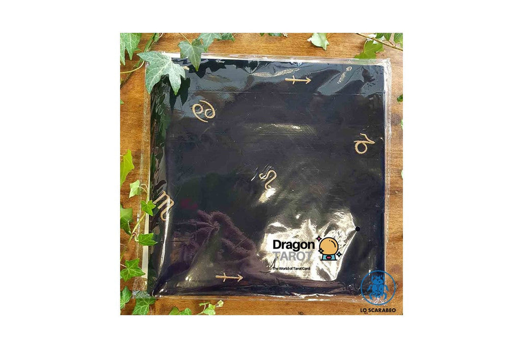 A black Dragon Aromatherapy cloth or mat wrapped in clear plastic packaging, displayed on a wooden surface with green leaves around it. The packaging features the Dragon Aromatherapy logo.