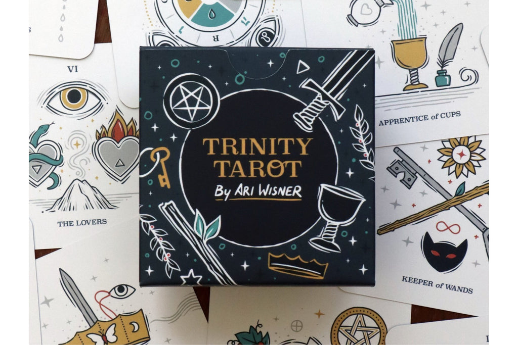 The box for the 'Trinity Tarot' deck by Ari Wisner is centered, surrounded by several illustrated tarot cards on a white background.