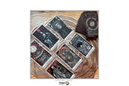 A set of illustrated tarot cards and a matching deck box arranged on a woven tray over a wooden surface. The cards feature dark fantasy-style artwork in black, gray, and red tones.