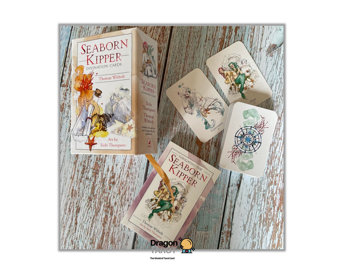 A boxed deck of illustrated cards titled "Seaborn Kipper" arranged on a distressed whitewashed wood surface, with the box standing upright and several cards fanned out beside it. A small Dragonfly Studio logo appears at the bottom center.
