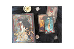 The Vampire's Tale Tarot deck by Sarah Grafton, displayed with its illustrated box on a black fabric background alongside three fanned tarot cards and small decorative stones and a candle.
