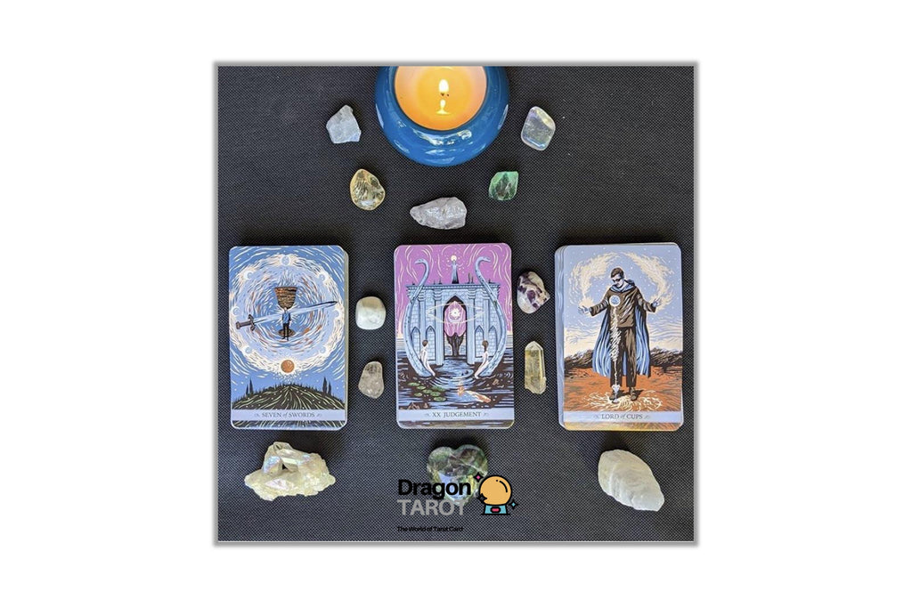 Three illustrated tarot cards are arranged on a dark surface with crystals and a lit candle. The cards show fantasy-style artwork, and the center card has a visible 'Dragon Tarot' logo near the bottom.