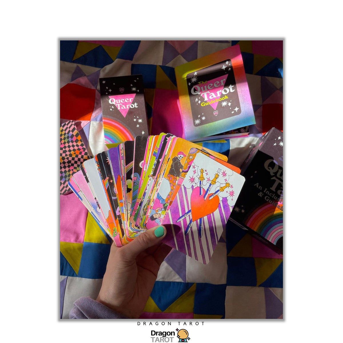 A hand holds a fan of colorful Dragon Phoenix 'Season 4' deck boxes and trading cards, set against a colorful geometric quilt background.