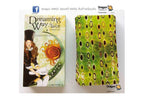 Dreaming Way Tarot deck shown with its illustrated box on the left and the rolled deck wrapped in a green patterned paper sleeve on the right, photographed against a plain white background.