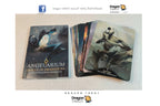 Angelarium Oracle of Emanations tarot deck and card box shown on a light beige surface, with several cards fanned out beside the box. The box cover and a card illustration feature dark fantasy artwork with a knight and a pale figure against a smoky background.