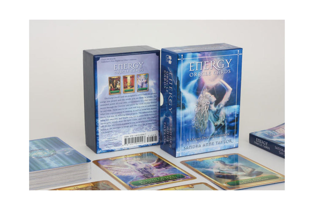 Energy Oracle Cards deck shown with its blue illustrated box, back cover, and several cards spread out on a light neutral surface.