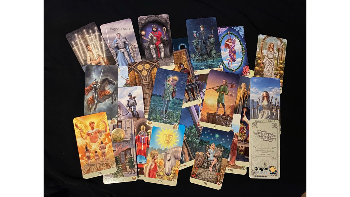 A spread of multiple illustrated tarot or oracle cards arranged on a black fabric background. The cards feature fantasy and historical scenes with figures, animals, and symbolic imagery in many different colors.