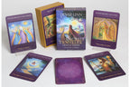 Sacred Traveler Oracle Cards deck by Denise Linn, showing the main box, two purple-bordered card fronts, two card backs, and a gold booklet on a light gray background.