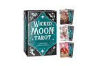 Wicked Moon Tarot deck box with three sample cards fanned out beside it on a plain white background. The box is dark teal and black with ornate white lettering and celestial illustrations, and the cards show colorful illustrated backs.